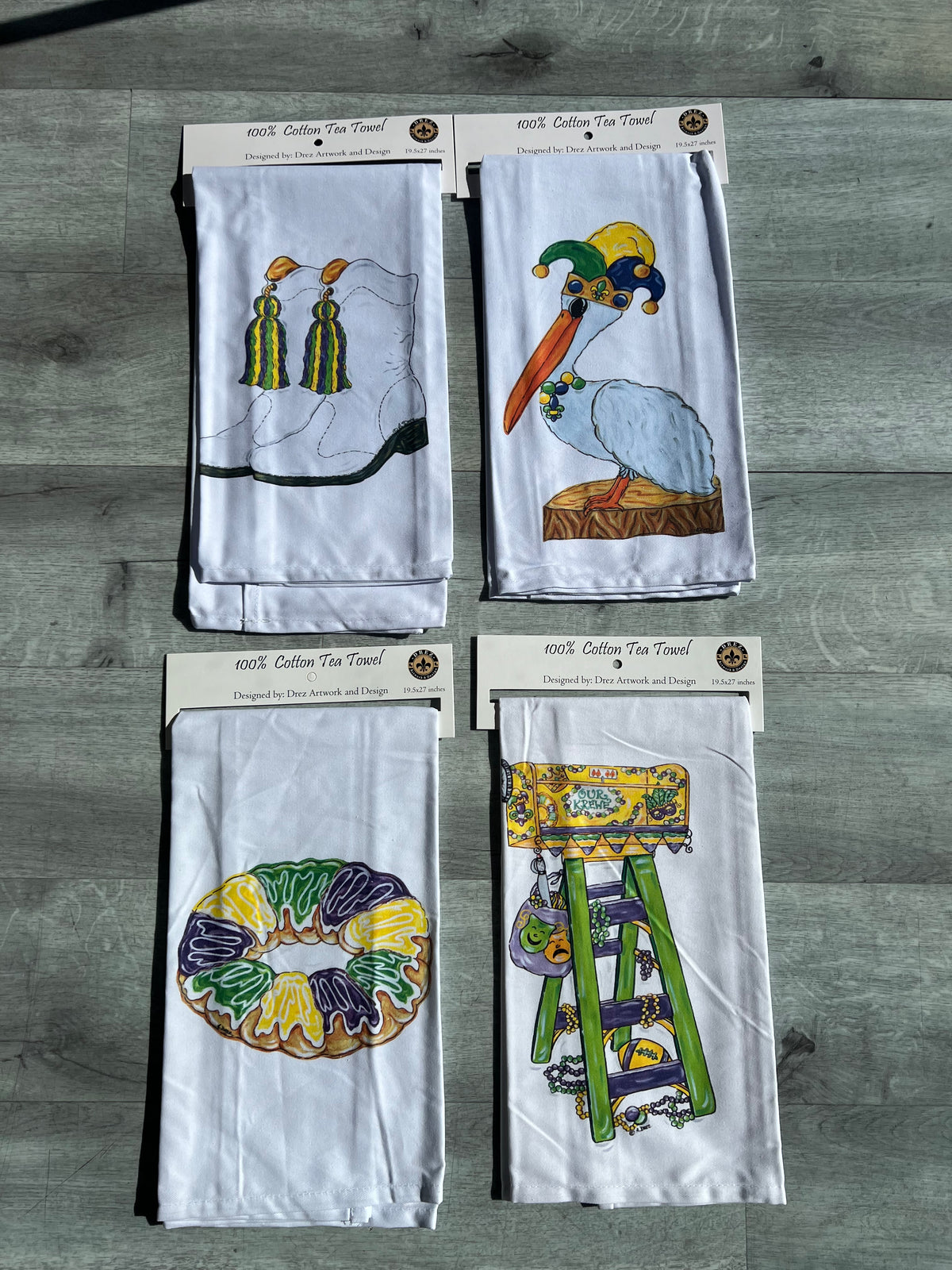 Four Mardi Gras tea towels with tassels, a pelican, king cake and a ladder