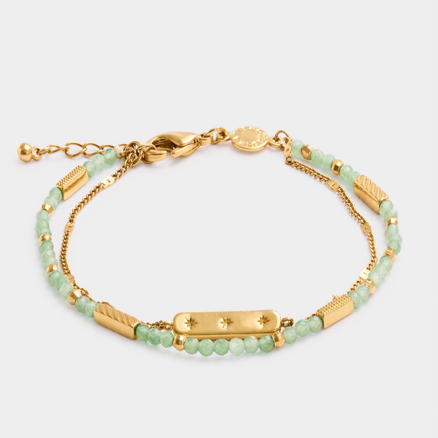 Gold chain bracelet with green beads and a central rectangular charm featuring three small star engravings