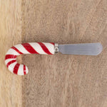 Spreader with a candy cane shaped handle on a wooden surface