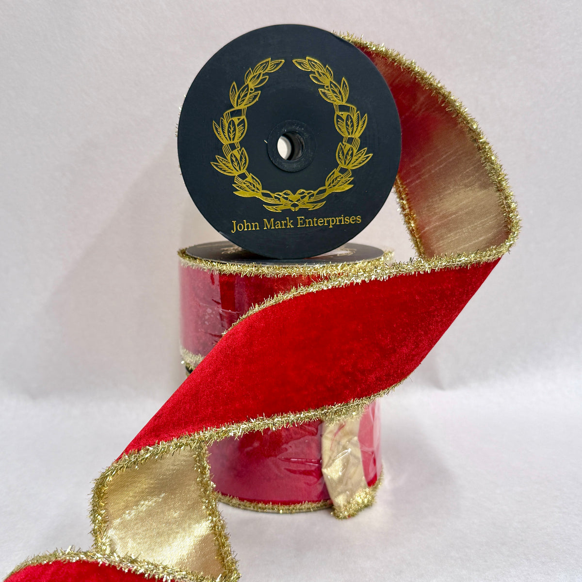 Spool of red velvet ribbon with gold metallic backing and tinsel edge
