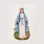 A door hanger featuring an illustration of a woman in a white and blue robe, with a halo, standing in a garden.