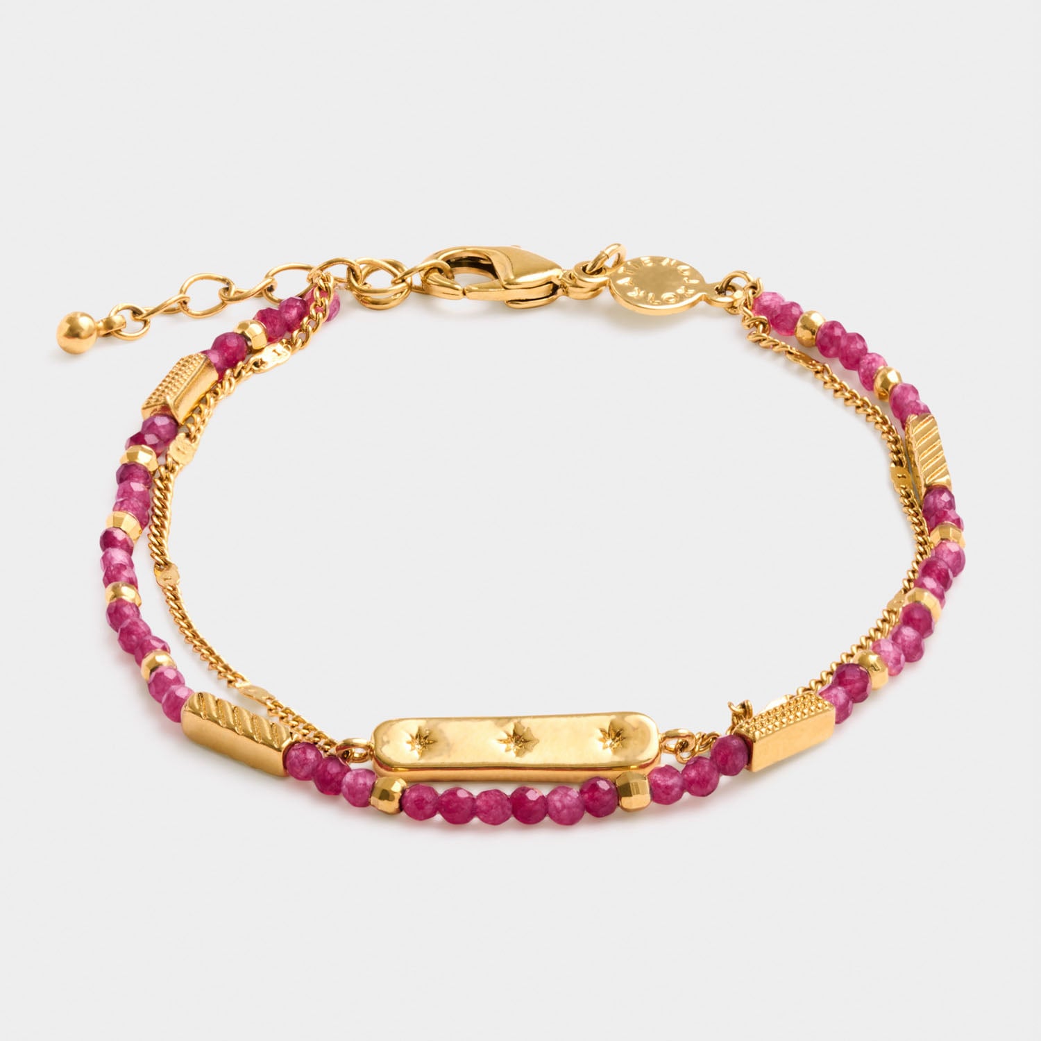 Gold chain bracelet with pink beaded strands and a central rectangular bar charm with star engravings