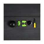 Witch costume accessories including a green face mask hands hat and broom on a black wooden surface
