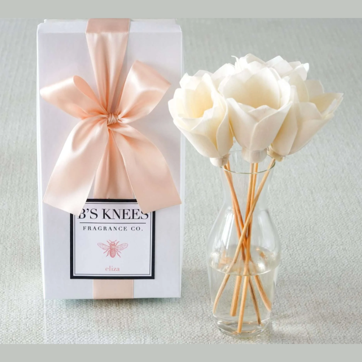 Fragrance diffuser with roses and packaging on a light background