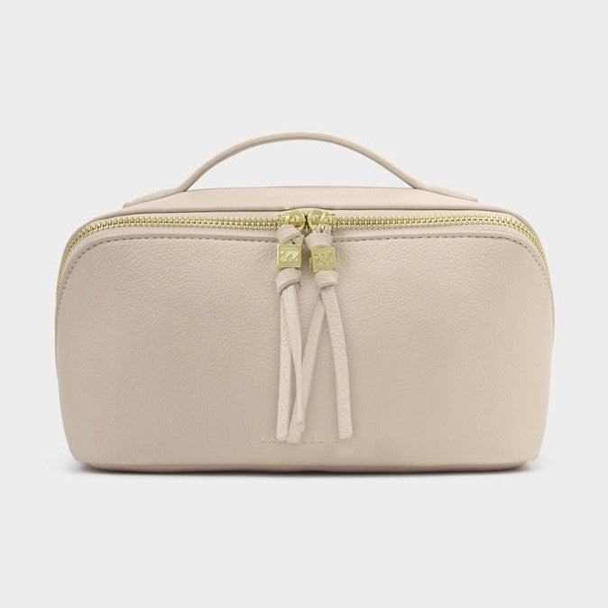 Beige toiletry bag with a gold zipper on a light gray background