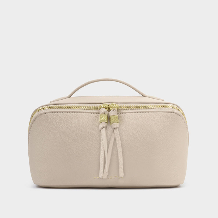 Beige toiletry bag with a gold zipper on a light gray background