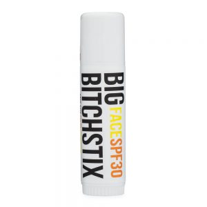 White cylindrical lip balm tube with black and orange text