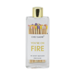 A clear glass bottle with a gold lid containing multicolored safety matches, labeled 'CHEZ GAGNE YOU'RE ON FIRE' with 40 safety matches inside.