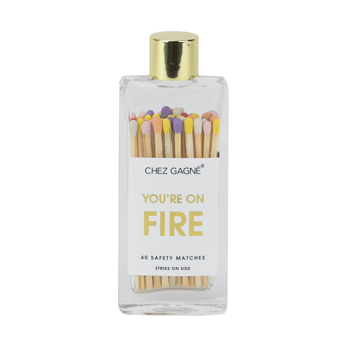 A clear glass bottle with a gold lid containing multicolored safety matches, labeled 'CHEZ GAGNE YOU'RE ON FIRE' with 40 safety matches inside.