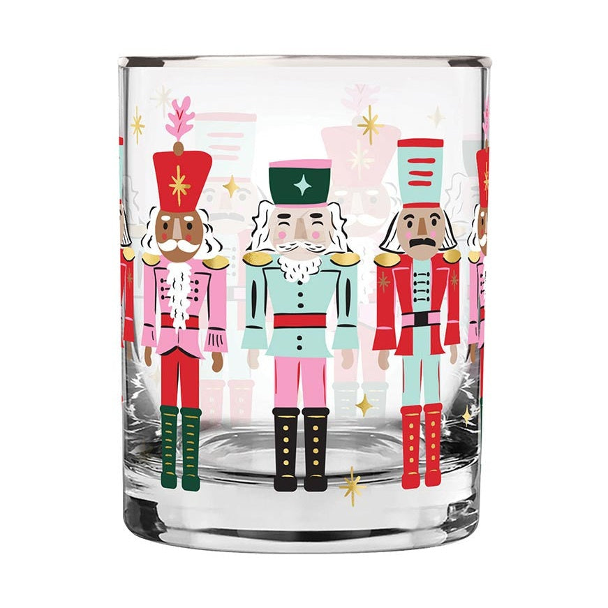 Clear glass tumbler decorated with colorful nutcracker illustrations and gold star accents