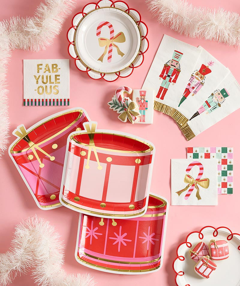 Holiday checkerboard and nutcracker napkins with drum plates on a pink table