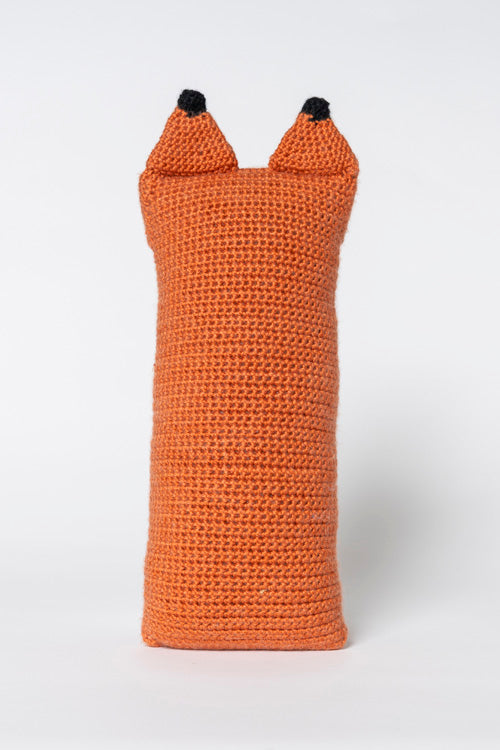 Crocheted orange fox-shaped item featuring a distinct textured surface and two pointed ears with black tips