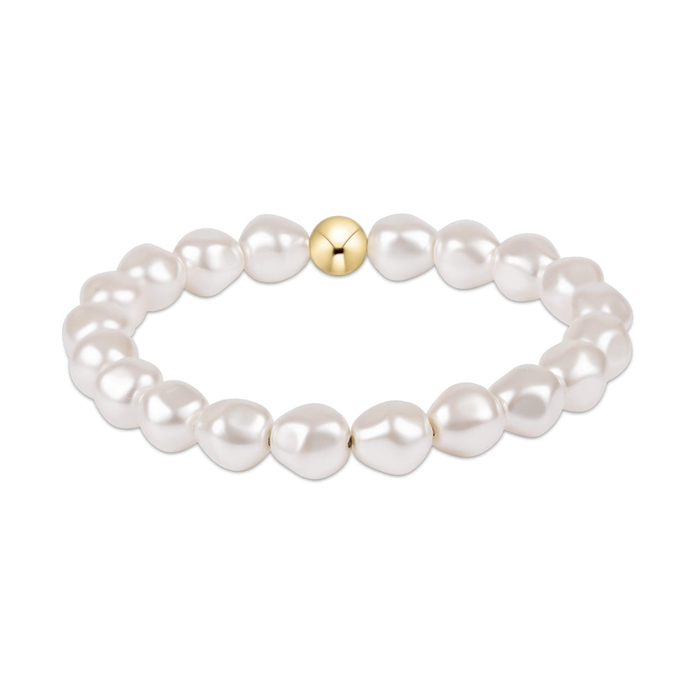 Stretch bracelet featuring white baroque pearls and a single gold bead
