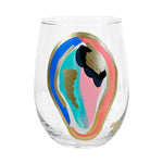 Clear wine glass with colorful abstract oyster shell design on a white background