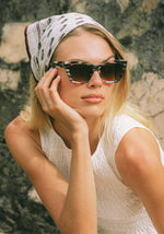 Woman in a bandana wearing tortoiseshell cat-eye sunglasses