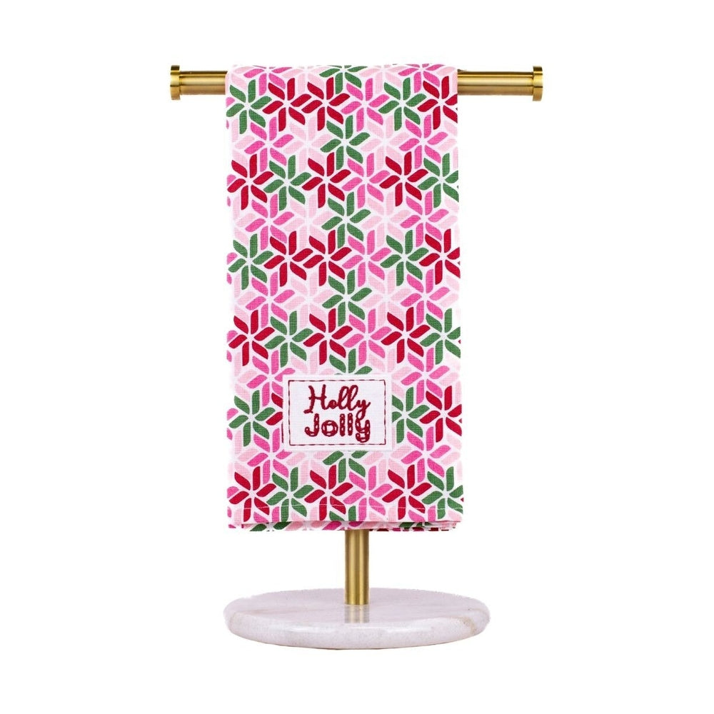 Hand towel with pink green and red geometric star pattern and Holly Jolly text on a gold stand