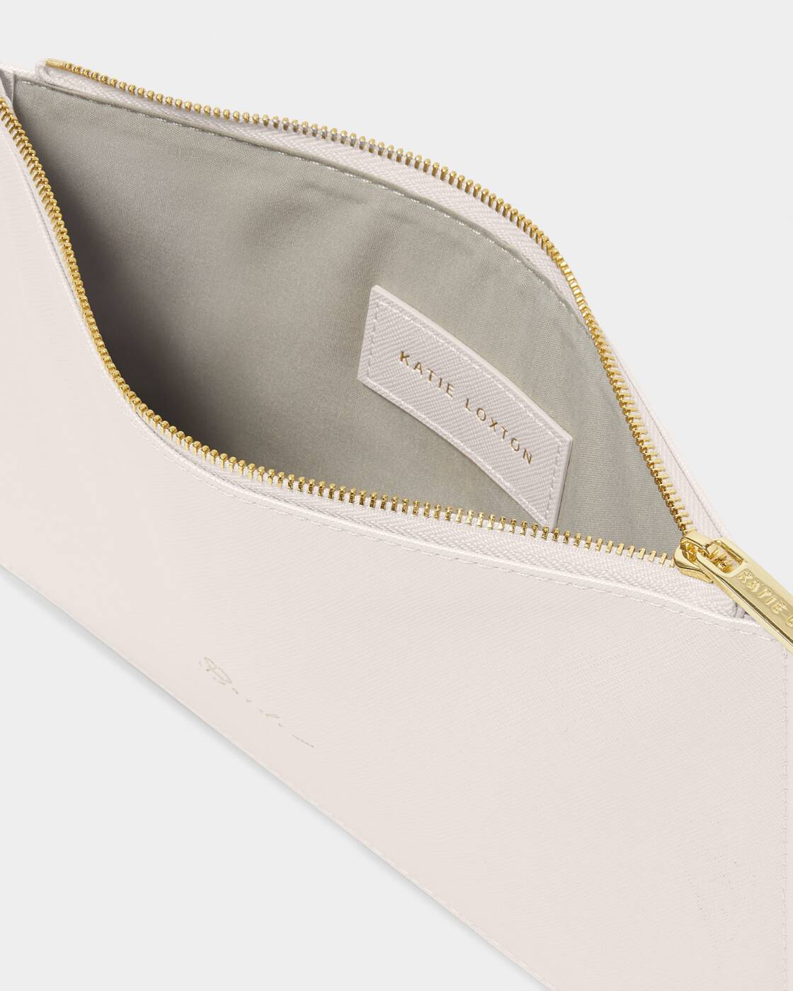 Katie Loxton white vegan leather pouch displayed open to showcase a metallic gold zipper, a grey fabric interior, and an internal brand logo patch against a clean studio backdrop