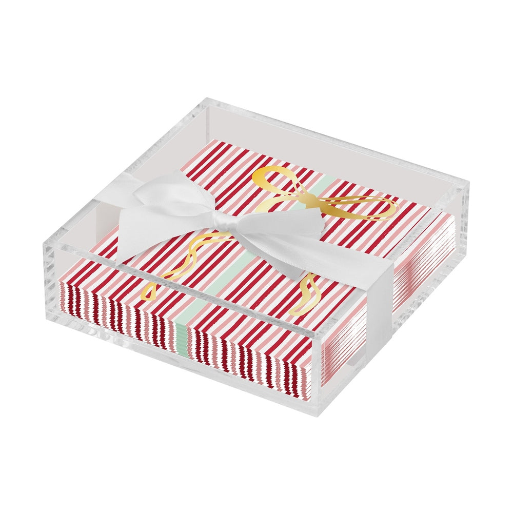 Stack of red and white striped napkins in a clear acrylic box tied with a white ribbon