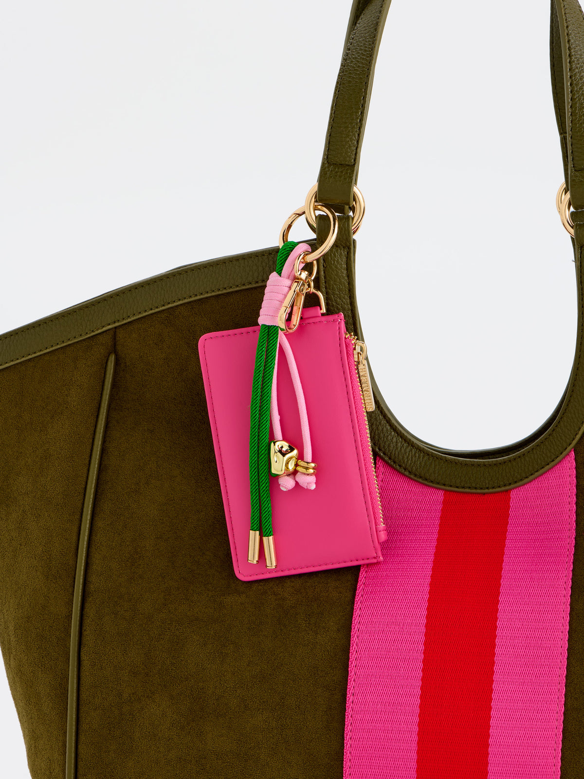 Pink card case charm clipped to an olive suede tote