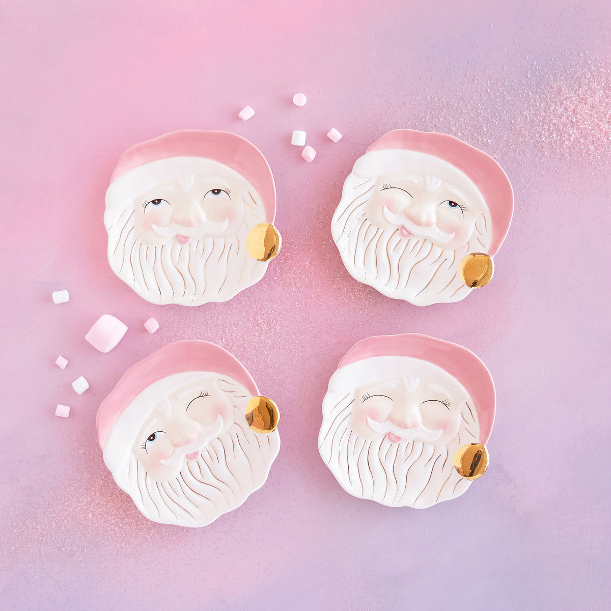 Four pink Papa Noel Santa face plates on a pink background