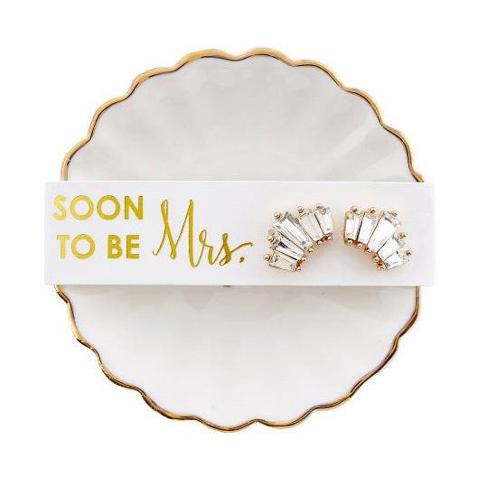 Pair of costume earrings on a 'Soon to be Mrs.' card on a decorative dish.