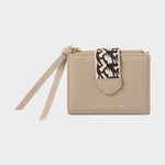 Beige wallet with a strap and patterned tag on a light gray background