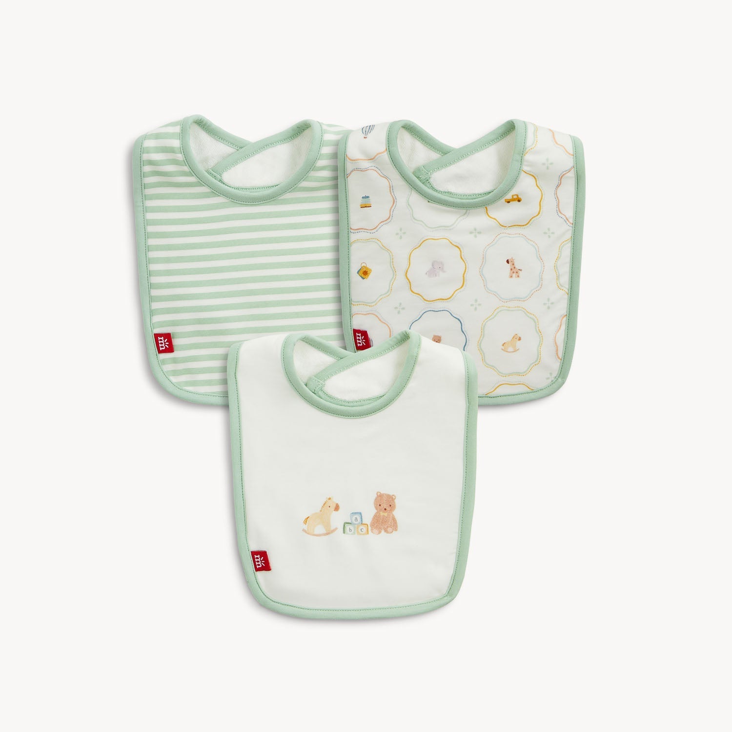 Three baby bibs with green trim featuring striped, patterned, and embroidered toy designs