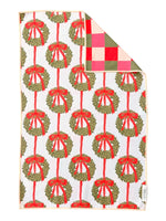 Hand towel printed with green wreaths on red ribbons, corner folded to show pink, red and green checks