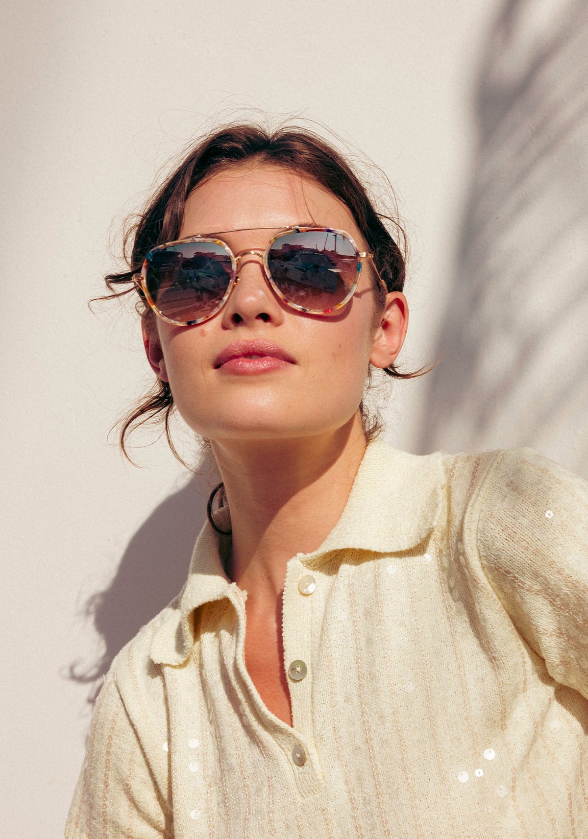 Woman wearing gold aviators with pink mirrored lenses