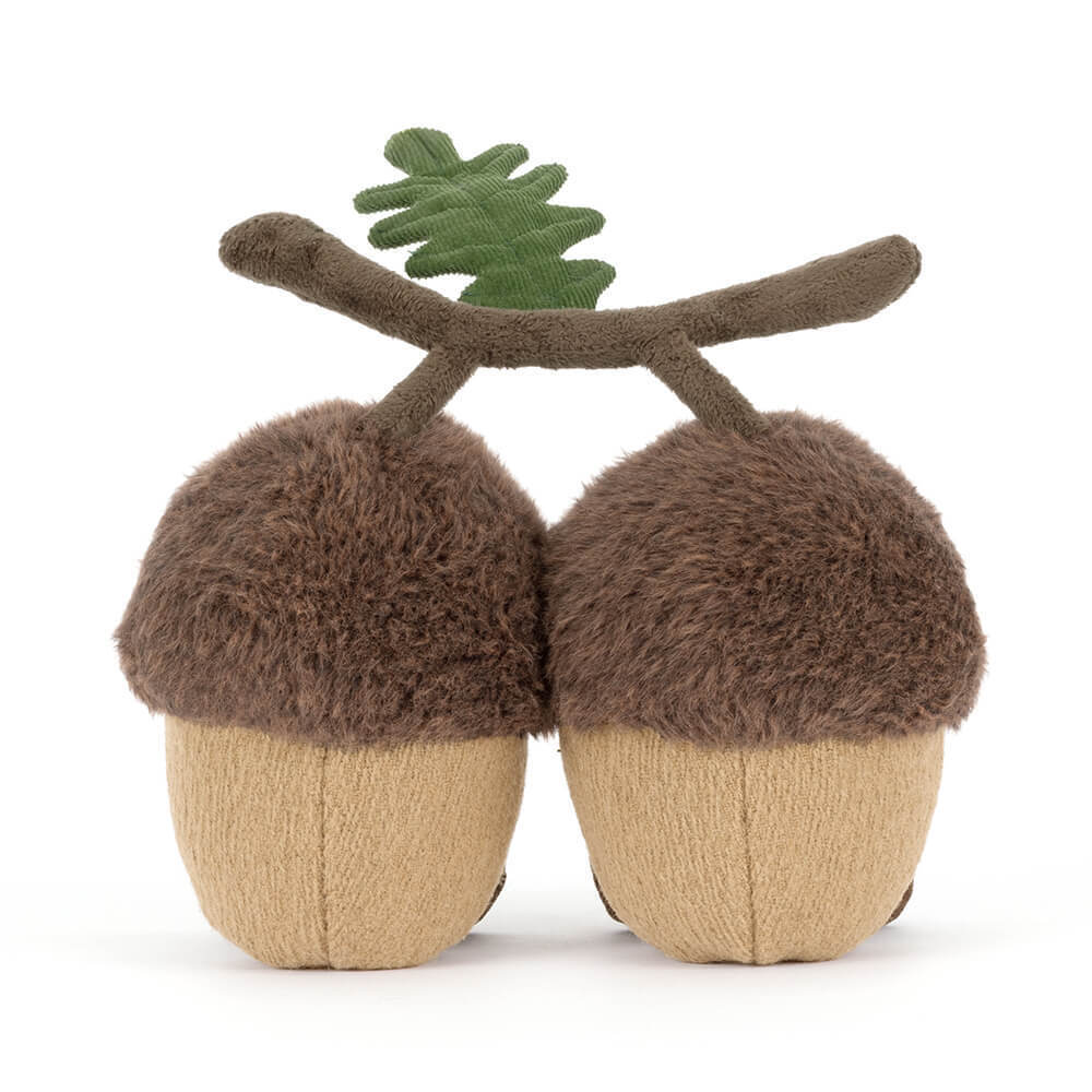 Back view of a stuffed acorn toy with a branch on a white background