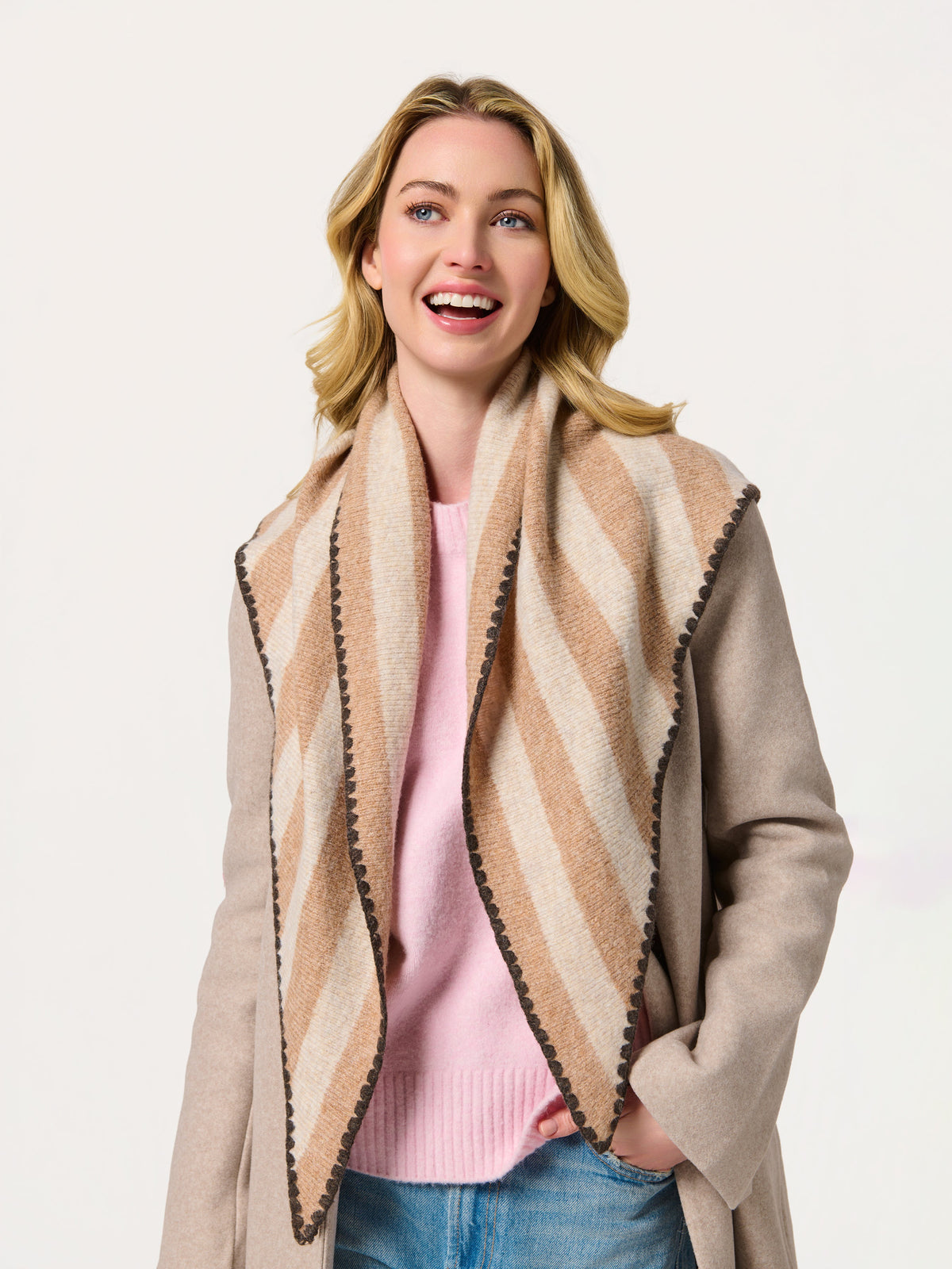 Woman wearing an oatmeal striped scarf draped open over a coat