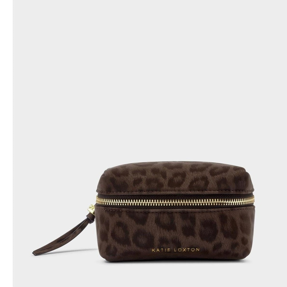 Product photograph by Katie Loxton of a dark brown leopard print makeup bag featuring a gold-toned wraparound zipper and an embossed brand logo set against a neutral studio backdrop