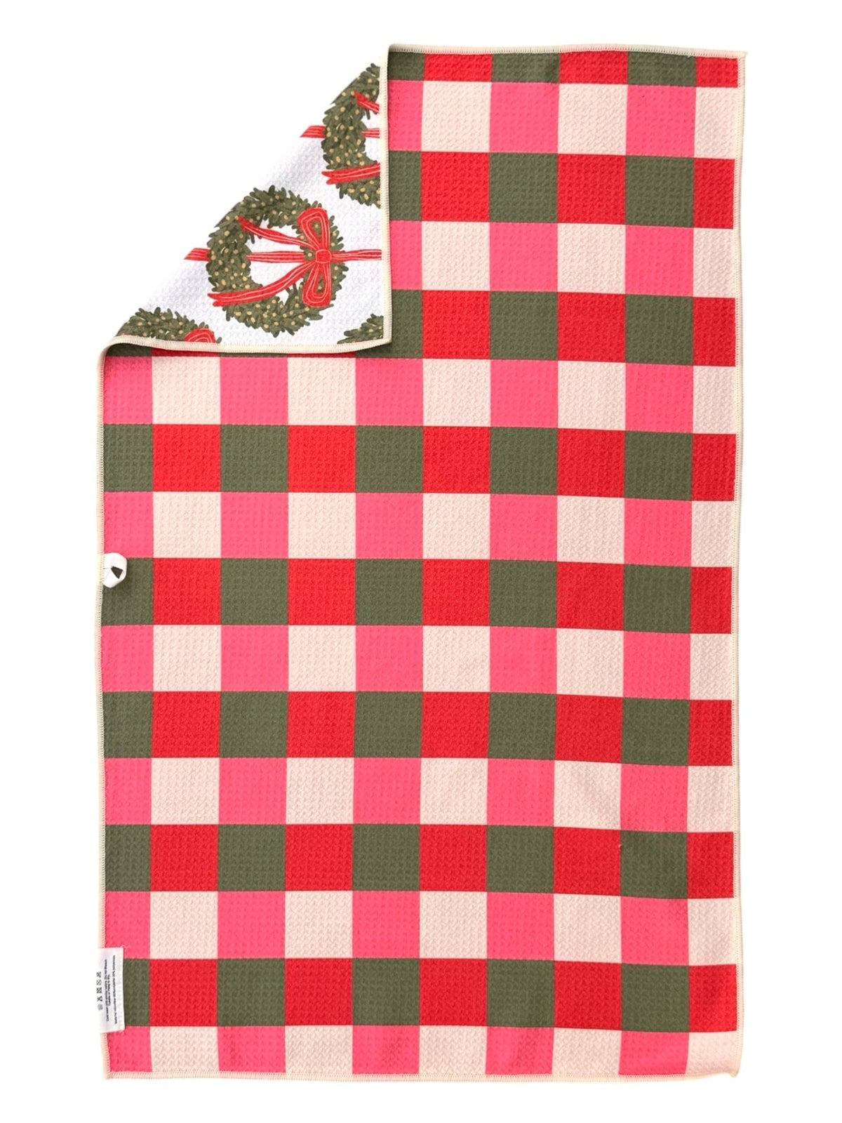 Hand towel with pink, red and green checks, corner folded to show the wreath print side
