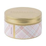 A tin candle with a gold lid and a checkered pattern on the container.