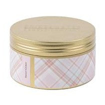 A tin candle with a gold lid and a checkered pattern on the container.