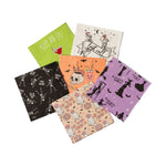 Six Halloween cocktail napkins fanned out in green, cream, orange, purple, black and peach ghost prints