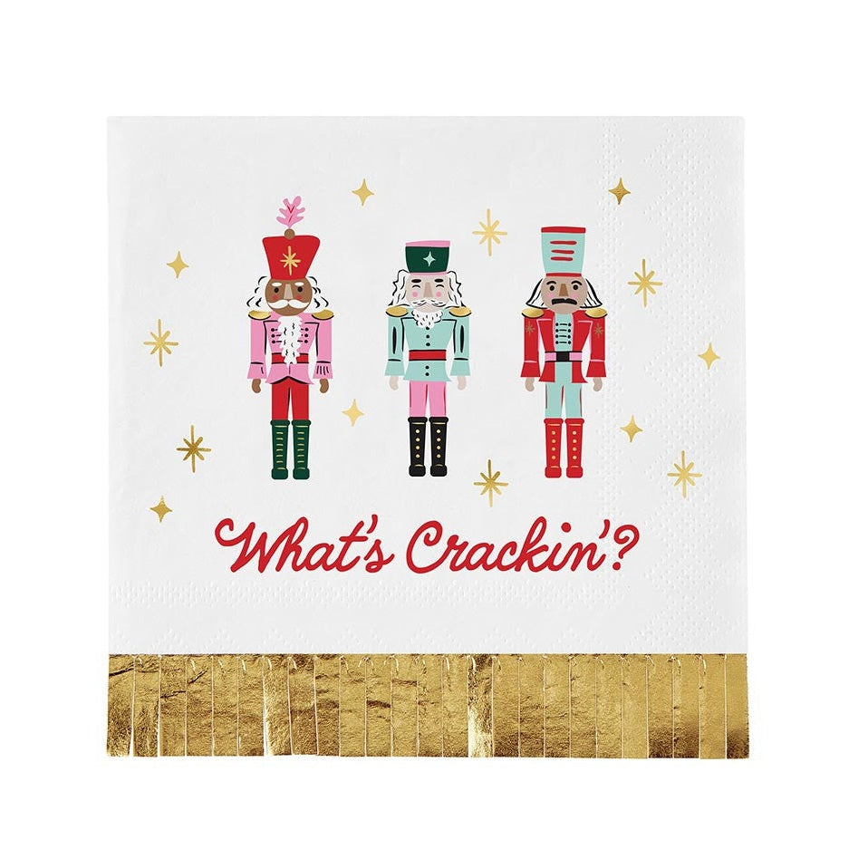 Cocktail napkin with three nutcrackers reading What's Crackin' and gold fringe