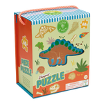 Illustrated puzzle packaging by Floss & Rock depicting a 60-piece stegosaurus shaped puzzle in a prehistoric scene with a fiery meteor, beige dinosaur fossils, and an orange and white striped rope handle