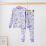 Lavender two-piece pajama set with a print of pelicans, oak trees, parasols and Mardi Gras beads