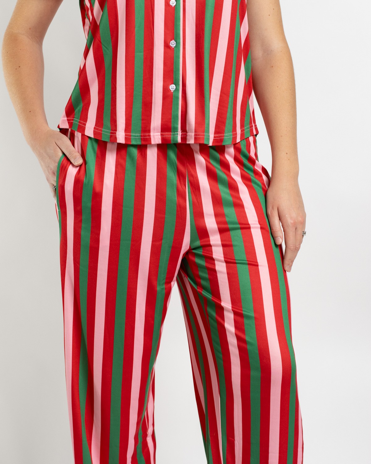 Person wearing red pink and green vertical striped pajama set