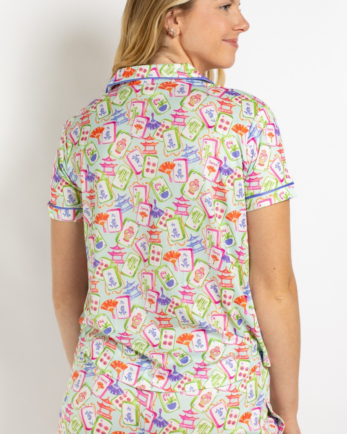 Woman wearing a light green pajama top with a colorful mahjong tile print