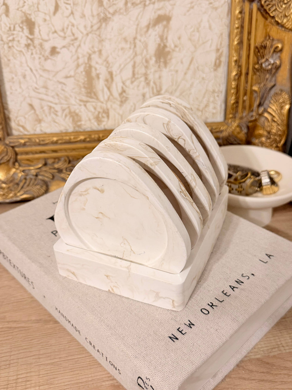 White marble coasters in a holder on a book