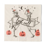 Cream cocktail napkin with two dancing skeletons holding drinks, a "last call" banner and jack-o'-lanterns