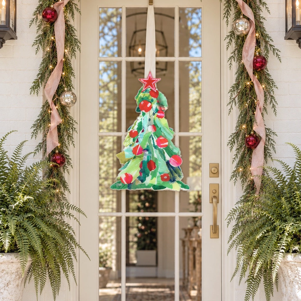 Painted green Christmas tree door hanger with red ornaments and a red star on a glass front door