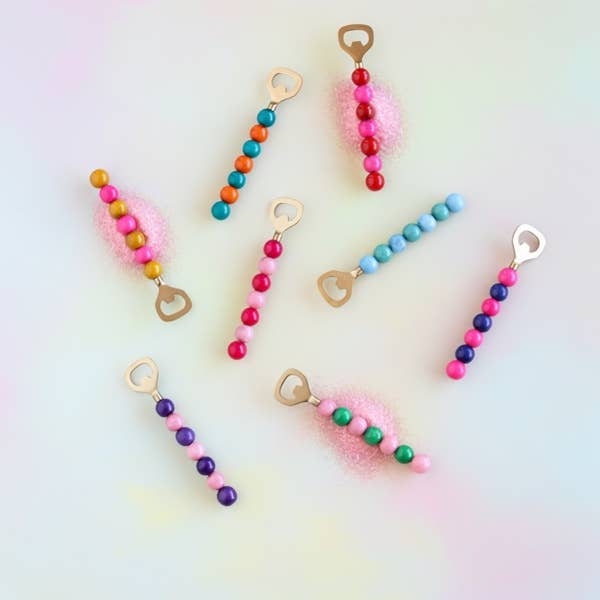 Seven beaded bottle openers in rainbow colors with gold heart-shaped openers
