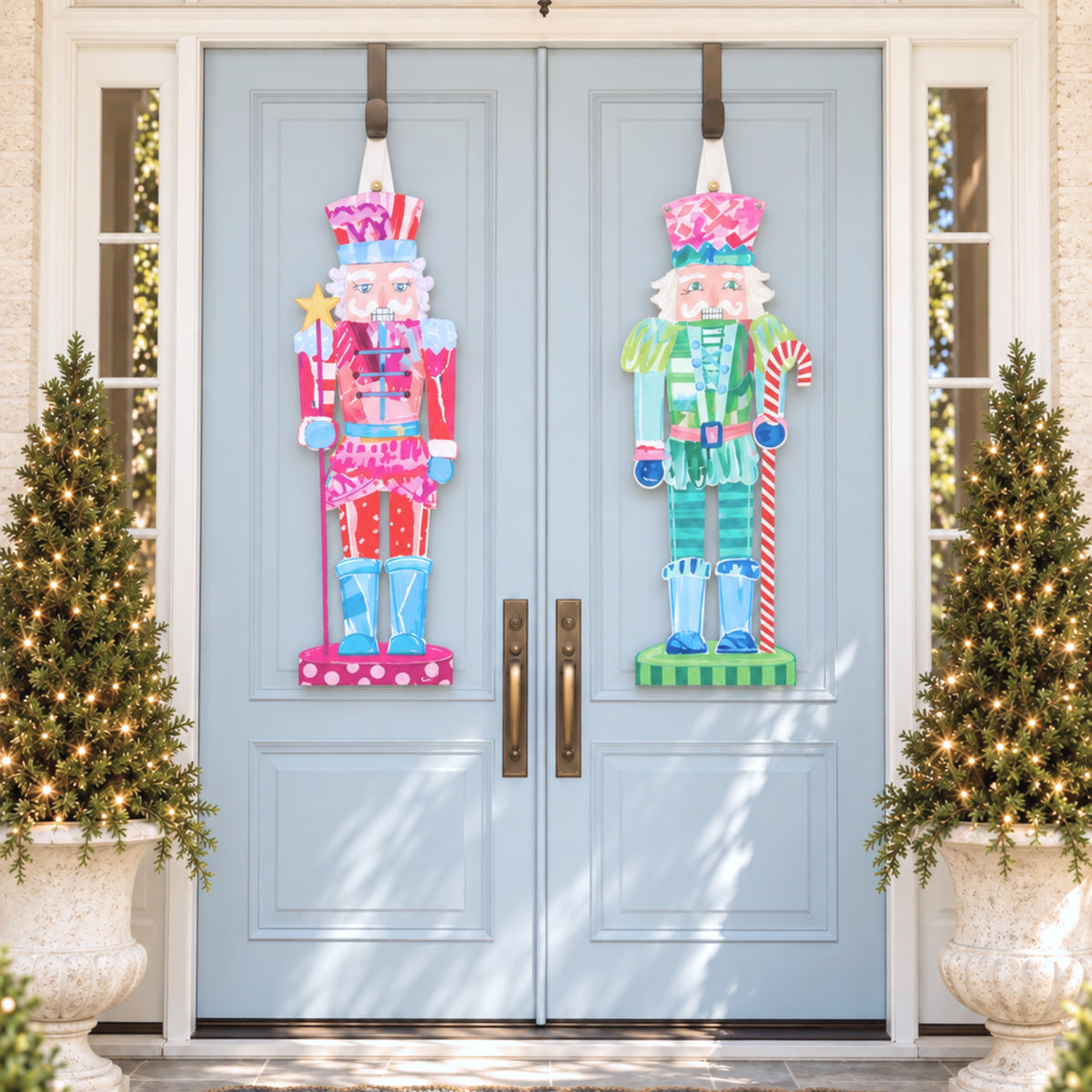Pink and red nutcracker and teal and green nutcracker door hangers on light blue double doors