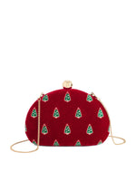 Embroidered red velvet clutch bag by Oscar de la Renta featuring a repeating motif of green Christmas trees, a polished gold-tone orb clasp, and a slender gold-link chain strap against a white background