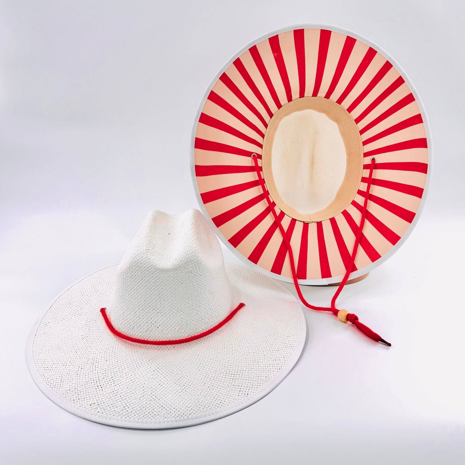White sun hat with red and beige circular design on a white background