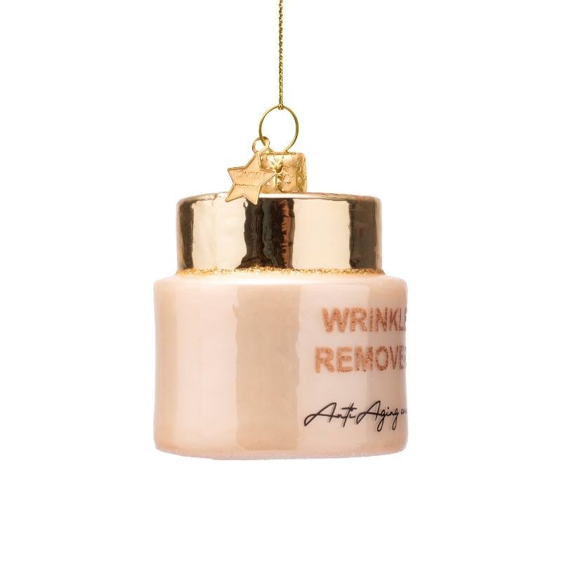 Glass Christmas ornament shaped like a cream jar with gold lid and text reading Wrinkle Remover Anti Aging