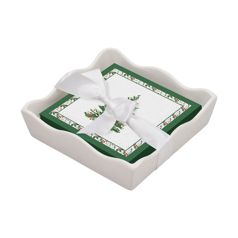 Stack of holiday napkins with holly print tied with a white ribbon in a white ceramic tray